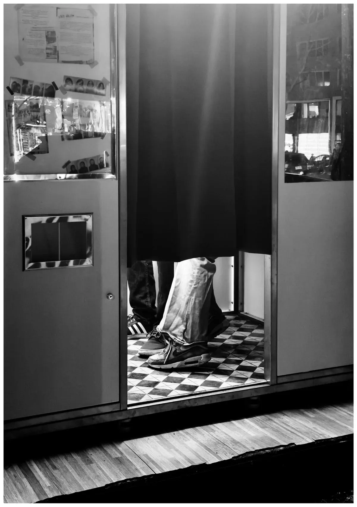 Feet behind the curtain of a black-and-white photobooth